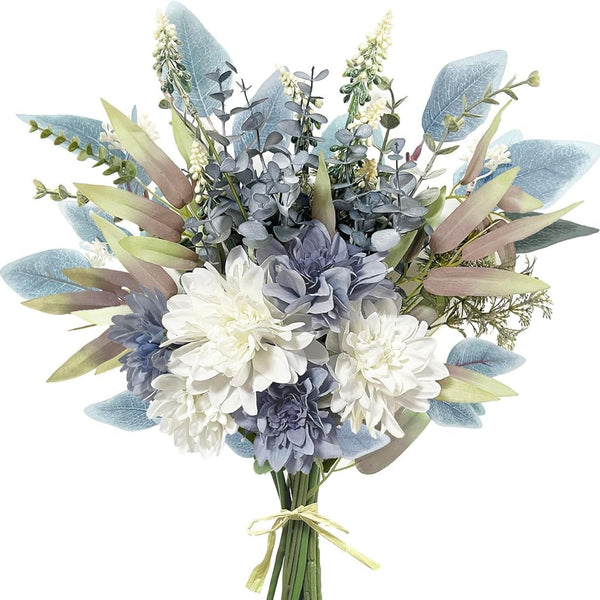 An artificial floral bouquet with white and blue flowers, dusty blue-green foliage, and muted beige leaves, tied with a light yellow ribbon at the stems against a plain white background.