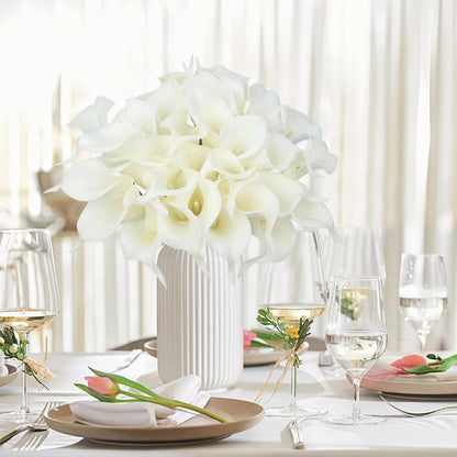 Elegant table setting with white flowers in a vase and clear glasses.