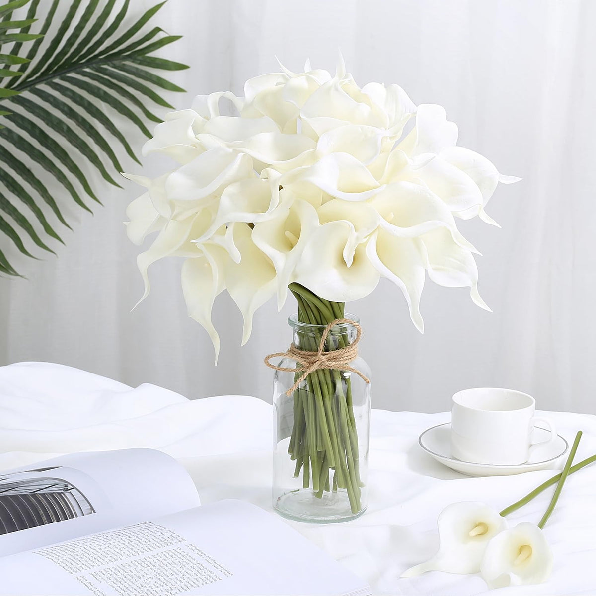Bouquet of white flowers in a clear vase on a table with a white background