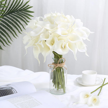 Bouquet of white flowers in a clear vase on a table with a white background