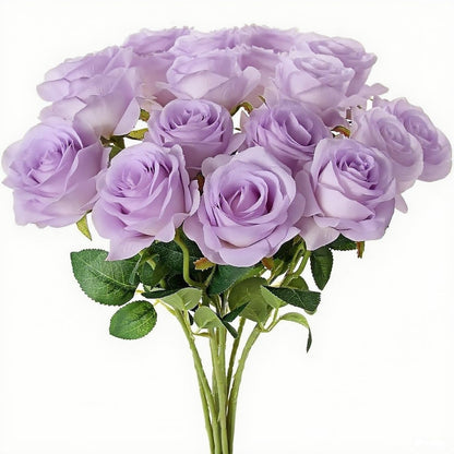 A bouquet of artificial light purple/lavender roses with green stems and leaves, photographed against a plain white background.