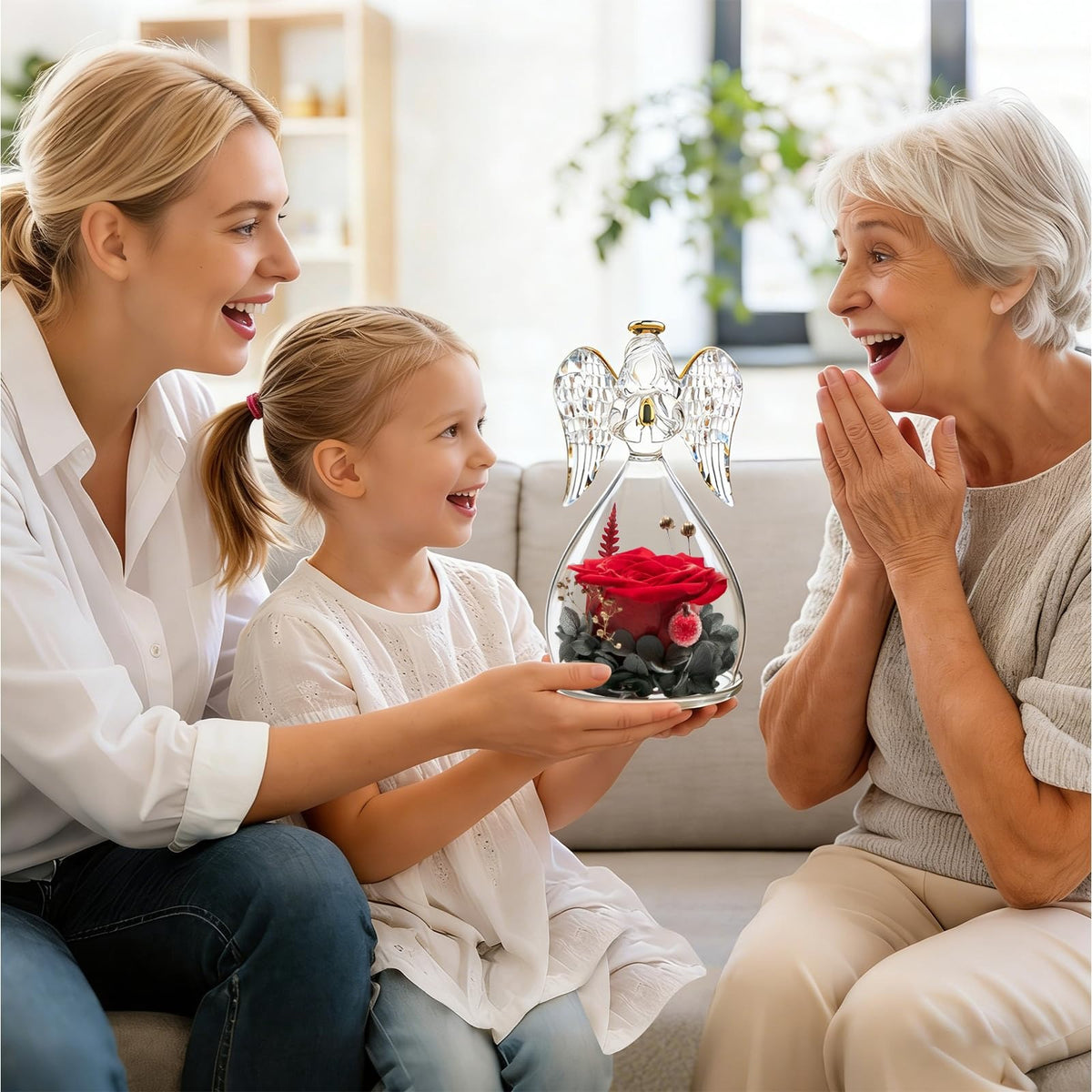 Woman, child, and elderly woman sitting together with a decorative angel holding red roses.